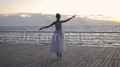 在<strong>日</strong>出或<strong>日</strong>落时，在海洋或海面上的堤岸上跳舞的芭蕾舞演员，身穿白色尖角。 <strong>青年</strong>